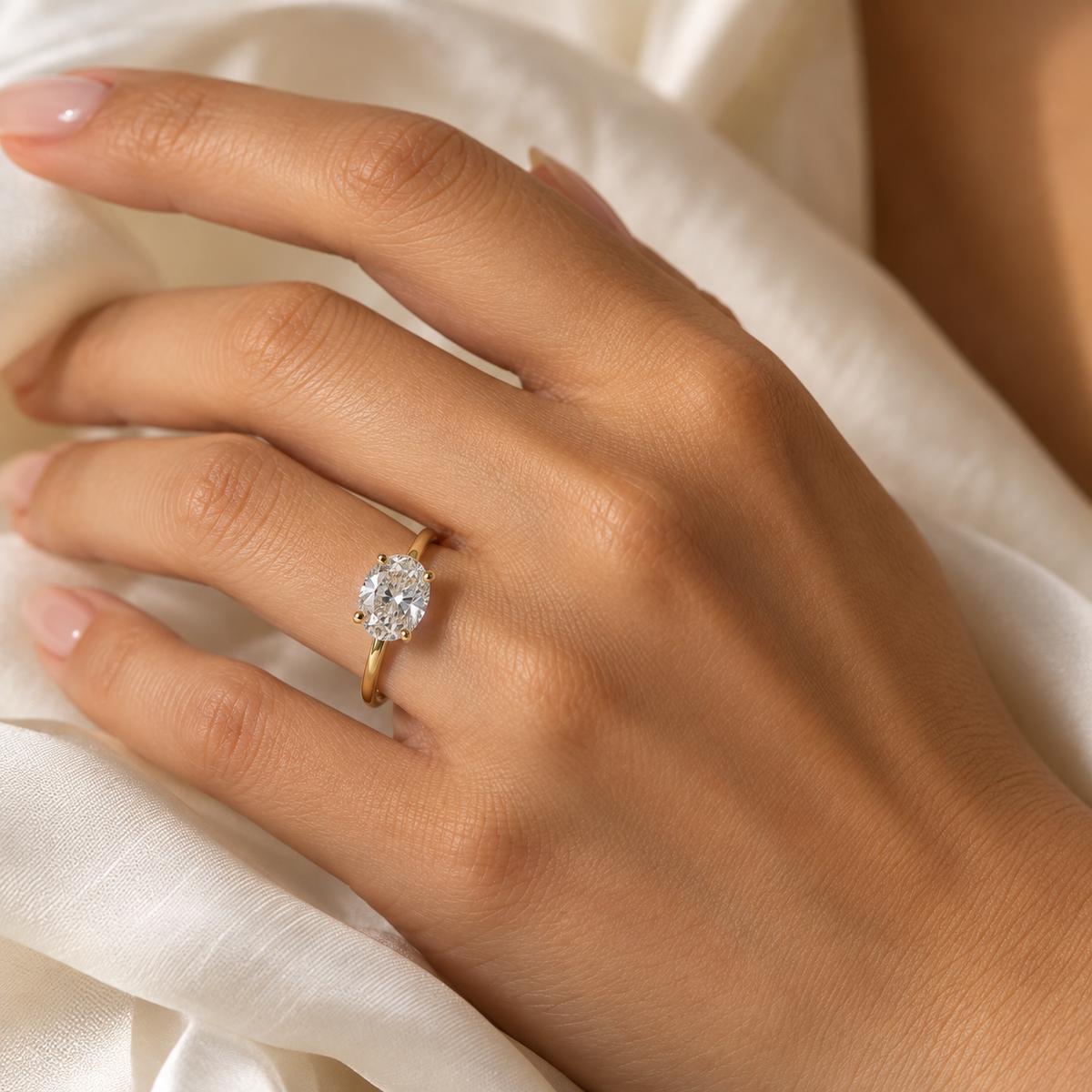 Model wearing an oval lab-grown diamond solitaire ring in yellow rhodium-finished sterling silver