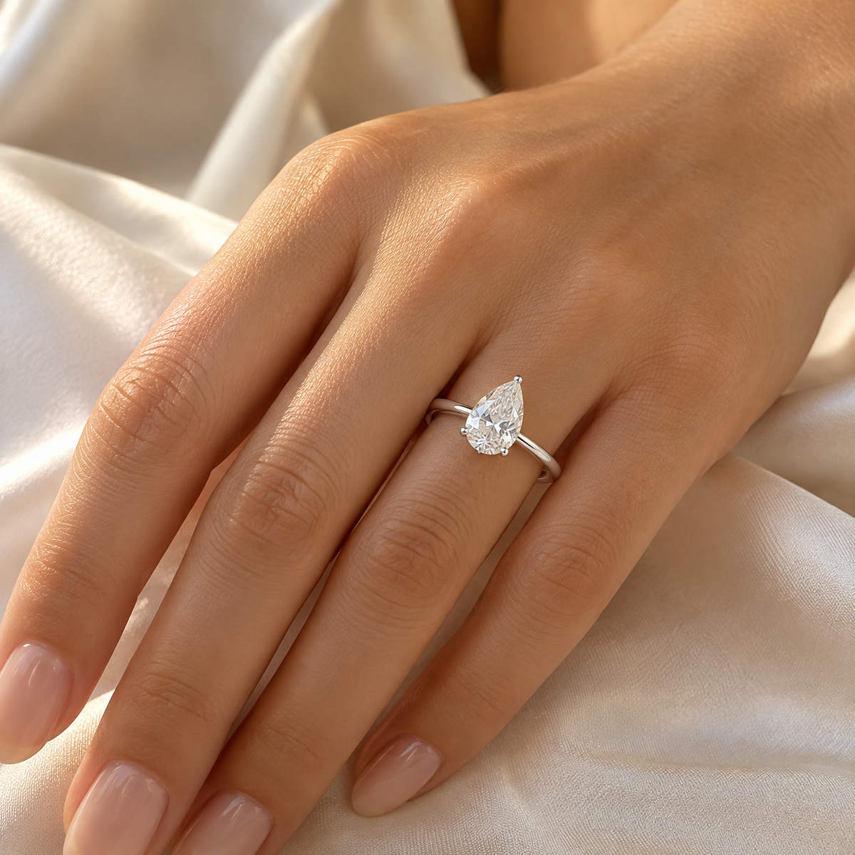 Model wearing a pear lab-grown diamond solitaire ring in white rhodium-finished sterling silver